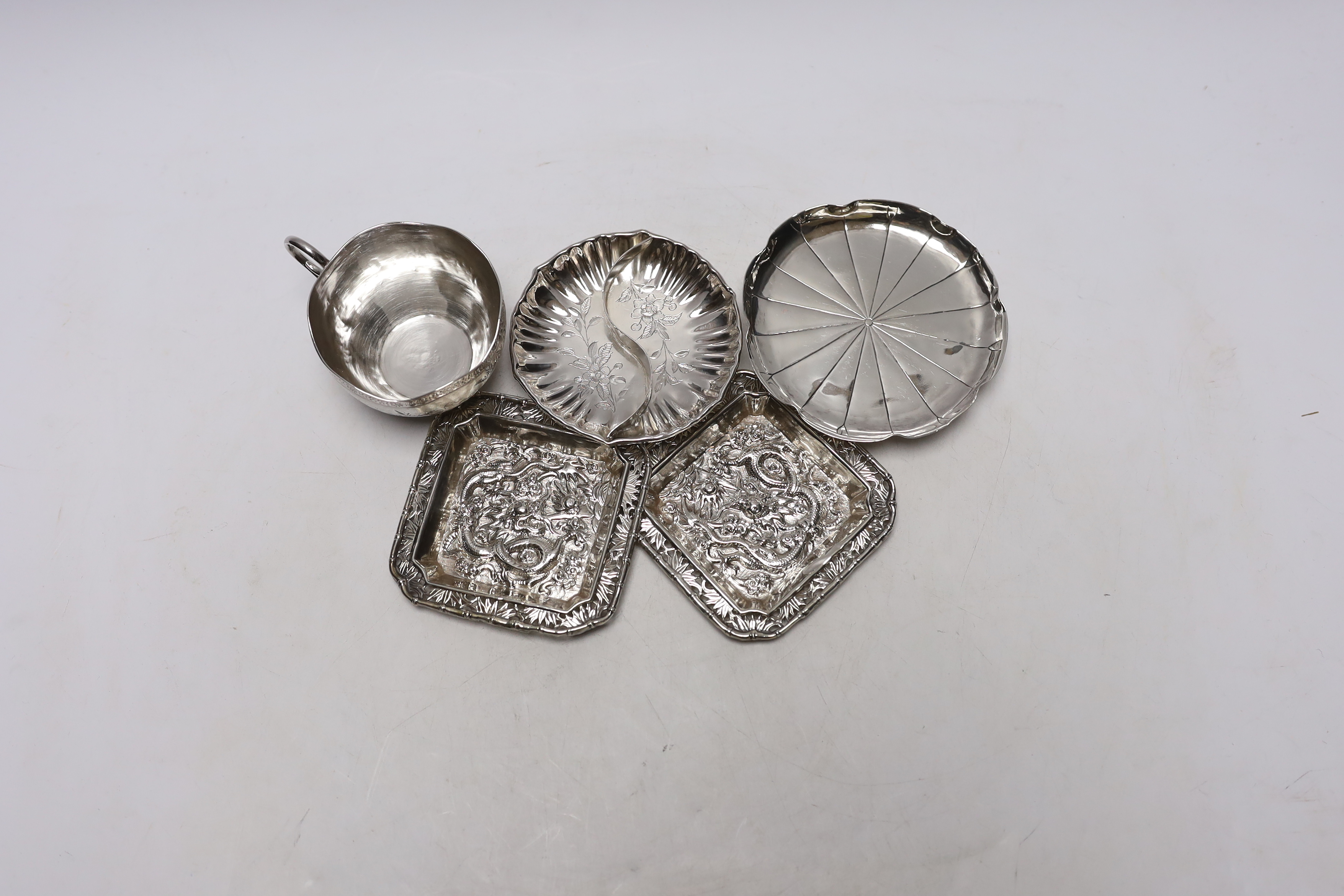 Chinese white metal items including two shaped dishes, a tea cup and two dragon dishes, largest 10.2cm, 8.2oz.